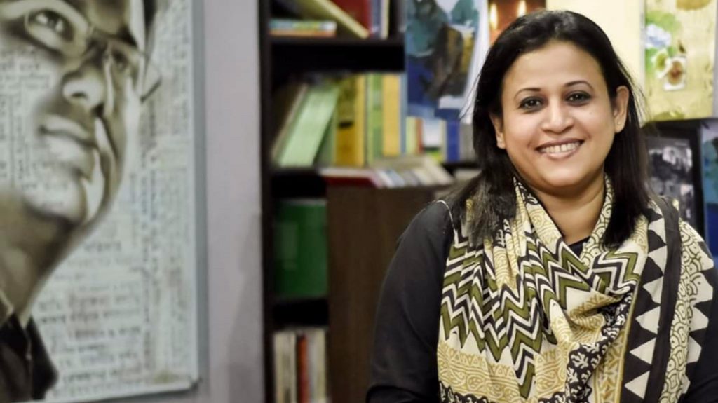 Razia Rahman Jolly stands in front of a mural of her late husband, Faisal Arefin Dipan, at Jagriti Publishing House in Bangladesh