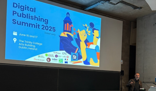 A man speaks from a lectern in a university lecture hall in front of a slide that reads “Digital Publishing Summit 2025, June 16 and 17, the Trinity College Arts Building, Dublin Ireland.” Logos of sponsors